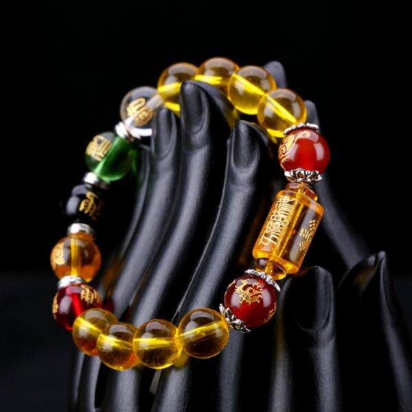 This vibrant bracelet features dominant golden-yellow citrine beads accented by red, green, black, and clear crystals representing the five elements, centered around an engraved wealth cylinder.