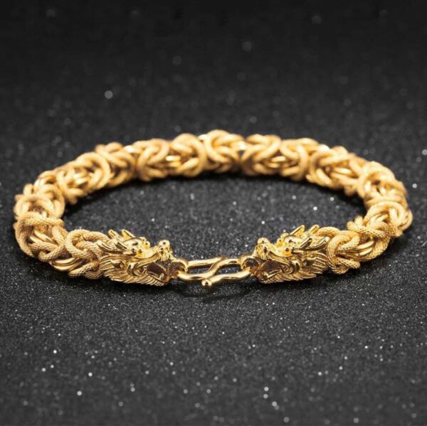 A lustrous gold-plated braided chain bracelet featuring two detailed dragon heads facing each other at the clasp.