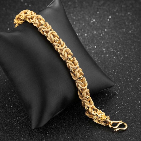 A lustrous gold-plated braided chain bracelet featuring two detailed dragon heads facing each other at the clasp.