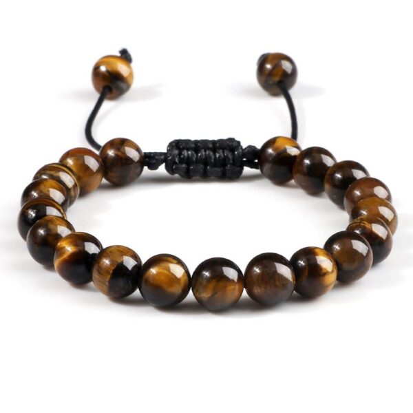A string of polished golden-brown tiger's eye beads exhibiting a silky chatoyant luster against a soft floral background.