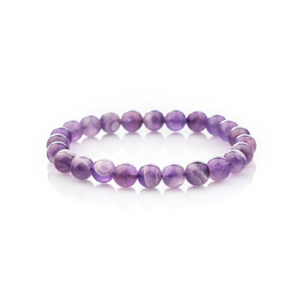 Polished round beads of deep violet amethyst are strung together to form a simple yet elegant bracelet resting on a natural fabric background.