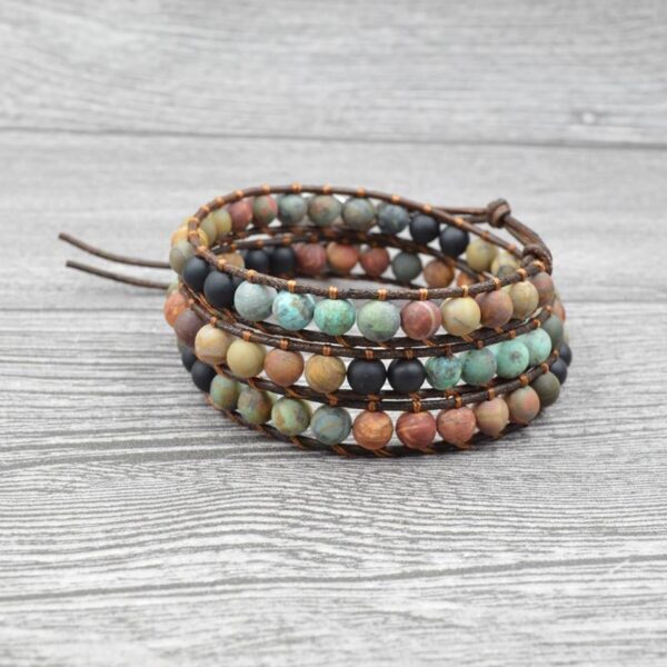 This multi-wrap bracelet features earthy multicolor agate beads strung on brown leather cord with a detailed silver heart charm.