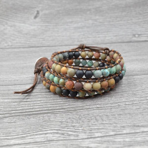 This multi-wrap bracelet features earthy multicolor agate beads strung on brown leather cord with a detailed silver heart charm.