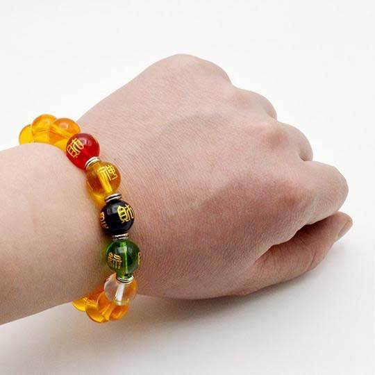 This vibrant bracelet features dominant golden-yellow citrine beads accented by red, green, black, and clear crystals representing the five elements, centered around an engraved wealth cylinder.