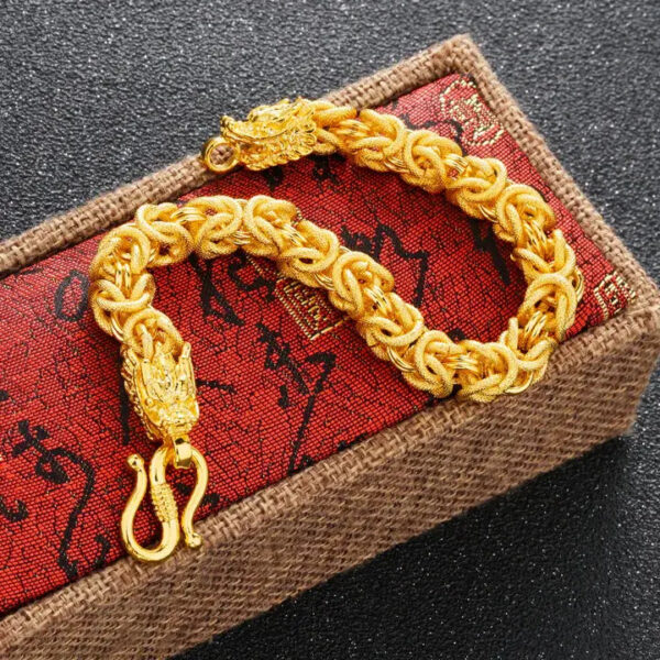 A lustrous gold-plated braided chain bracelet featuring two detailed dragon heads facing each other at the clasp.