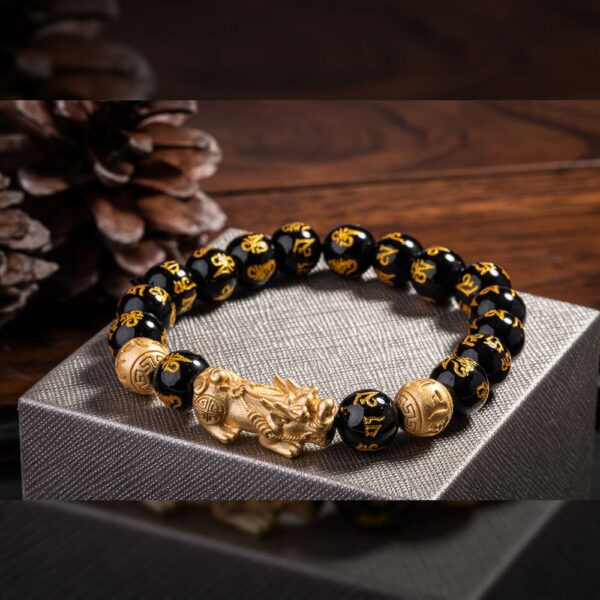 Glossy black obsidian beads engraved with golden mantras are centered by a detailed gold Pixiu beast and coin charms.