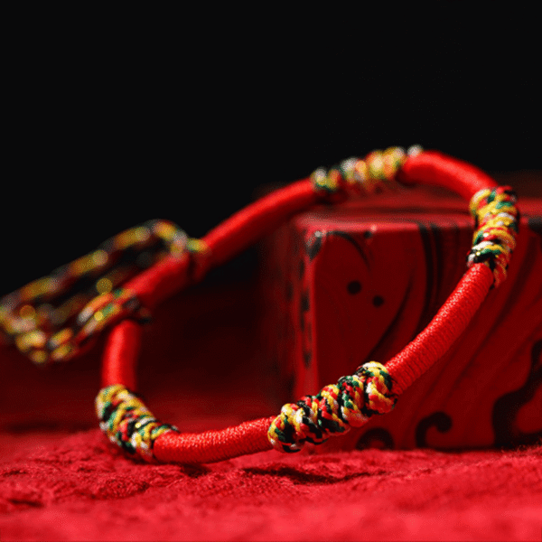 A woven adjustable string bracelet featuring interlaced threads of red, green, yellow, white, and black representing the sacred Panchavarna.
