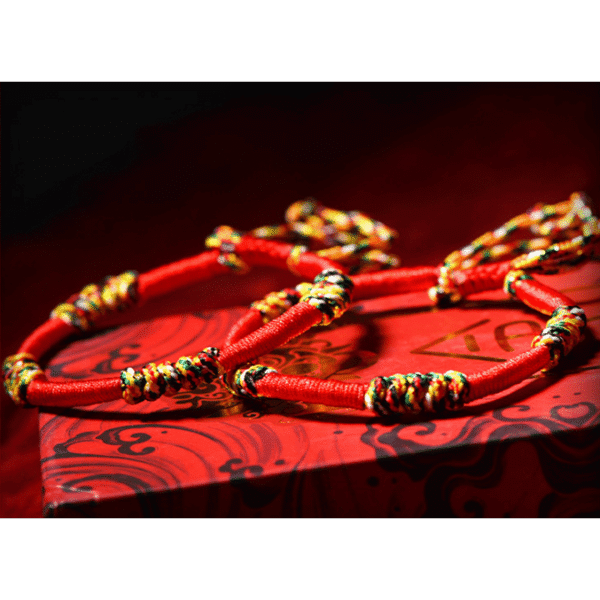 A woven adjustable string bracelet featuring interlaced threads of red, green, yellow, white, and black representing the sacred Panchavarna.