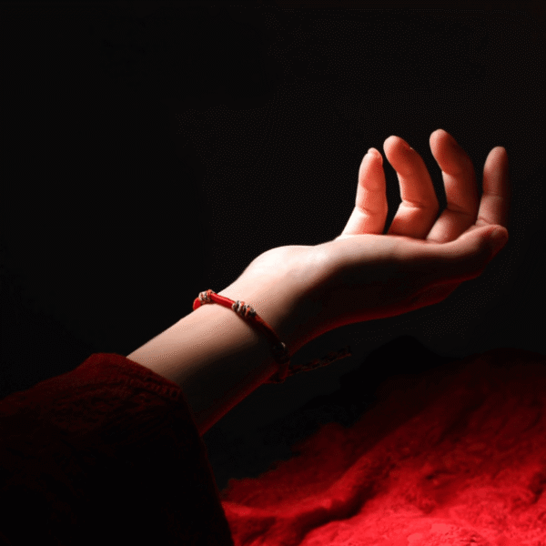 A woven adjustable string bracelet featuring interlaced threads of red, green, yellow, white, and black representing the sacred Panchavarna.