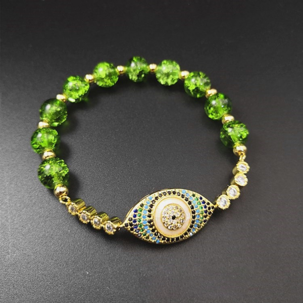 Vibrant green peridot beads surround a central protective evil eye charm on an adjustable cord.