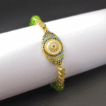 Vibrant green peridot beads surround a central protective evil eye charm on an adjustable cord.