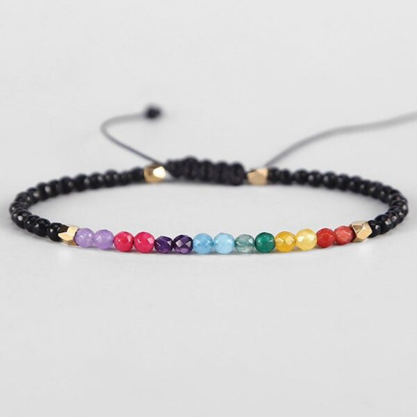 Two adjustable beaded bracelets featuring a spectrum of colorful chakra stones and mixed earth-toned gemstones set against black cords with gold accents.