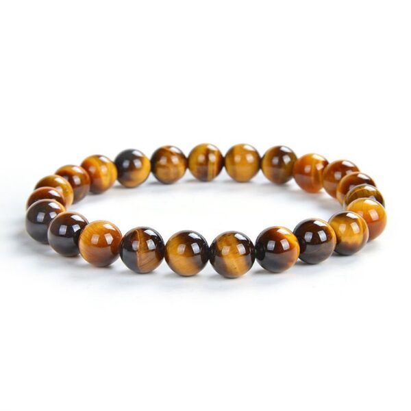 A string of polished golden-brown tiger's eye beads exhibiting a silky chatoyant luster against a soft floral background.